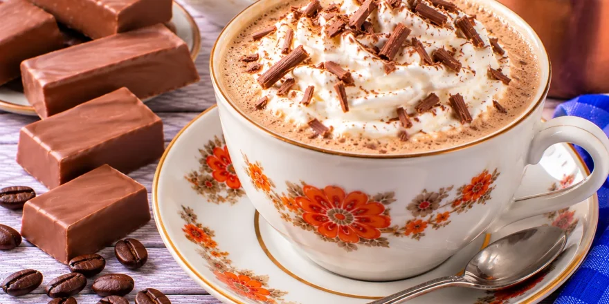 Heißer Nougatkaffee mit Milch und einer Haube aus geschlagener Sahne.