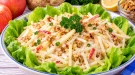 Würziger Apfelsalat mit Selleriestreifen, gehackten Nüssen und Mayonnaise.
