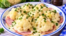 Blumenkohlröschen auf Schinkenscheiben mit cremiger heller Soße und Petersilie.