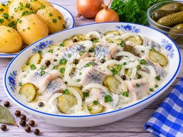Heringsfilets mit Gewürzgurke und Zwiebeln in cremiger Mayonnaise-Sahne-Soße.