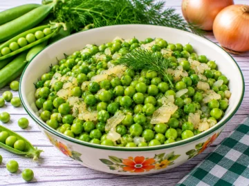Junge grüne Erbsen mit Butter, gedünsteten Zwiebeln und frischem Dill.