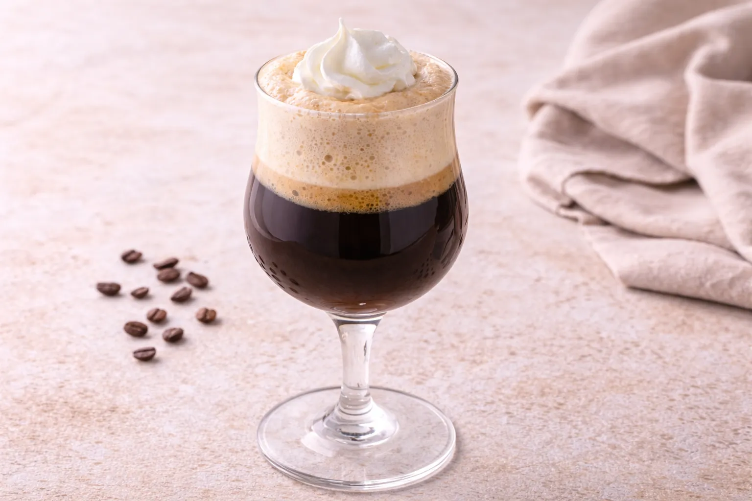 Schichtkaffee mit Sahne und Schaum in einem Stielglas