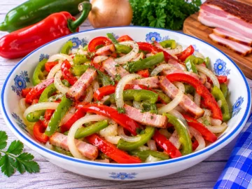 Peperonisalat aus roten und grünen Peperoni mit geräuchertem Speck und Zwiebeln.