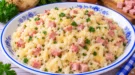 Cremiger Selleriereis mit Sellerie, Schinkenwürfeln und geschmolzenem Käse.