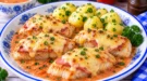 Goldbraunes Fischfilet mit Schinken und geschmolzenem Käse sowie cremiger Tomatensoße.