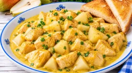 Curry-Huhn mit Hühnerbrust und Birnenstücken in cremiger gelber Currysoße.