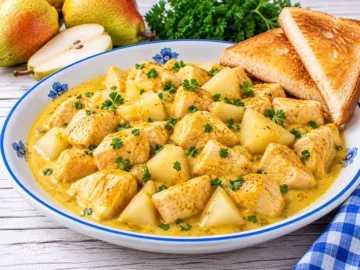 Curry-Huhn mit Hühnerbrust und Birnenstücken in cremiger gelber Currysoße.