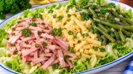 Dreifarbensalat mit Schinkenstreifen, Käse, grünen Bohnen und frischem Blattsalat.
