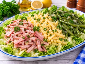 Dreifarbensalat mit Schinkenstreifen, Käse, grünen Bohnen und frischem Blattsalat.