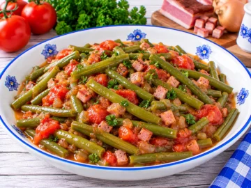 Grüne Bohnen mit Tomaten, Schinken und Zwiebeln in würziger Tomatensoße.