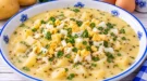 Cremige Kartoffelsuppe mit saurer Sahne, gehacktem Ei und Petersilie.