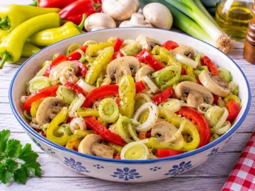 Peperonisalat mit Champignons und feinen Porreeringen in Essig-Öl-Vinaigrette.