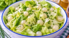 Frischer Kopfsalat mit ganzen Einmachzwiebeln und Schnittlauch-Vinaigrette.