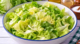 Frischer grüner Kopfsalat mit einem einfachen Dressing aus Öl, Essig, Zucker und Salz.
