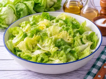 Frischer grüner Kopfsalat mit einem einfachen Dressing aus Öl, Essig, Zucker und Salz.