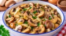 Gedünstete Pilze mit Zwiebeln, Butter und Kümmel in einer Pfanne.