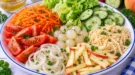 Bunter Gemüsesalat mit Möhren, Gurke, Sellerie, Apfel, Tomaten und zwei verschiedenen Dressings.