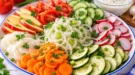 Bunte Rohkostplatte mit Tomaten, Gurken, Möhren, Rettich, Zucchini, Radieschen und Knoblauchsoße.