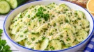 Gurkensalat mit cremiger Eisoße, geriebenem Hartkäse und frischen Kräutern.