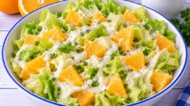 Frischer Kopfsalat mit Orangenstücken und cremigem Sahnedressing.