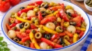 Orientalischer Salat – Pikant mit Paprika, Oliven und Peperoni Orientalischer Salat ist eine farbenfrohe und würzige Mischung aus Tomaten, Paprika, Einmachzwiebeln, Peperoni und Oliven. Die verschiedenen Gemüse sorgen für knackige und saftige Komponenten, während eine pikante Salatsoße aus Ketchup, Senf, Essig und Öl den kräftigen Geschmack bestimmt. Die Kombination aus Tomaten und Paprika bildet die frische Grundlage. Dazu kommen kleine Einmachzwiebeln mit ihrer süß-säuerlichen Würze sowie Oliven, die dem Salat eine herzhafte Note verleihen. Für eine leichte Schärfe sorgen Peperoni. Je nach Sorte kann der Salat mild-pikant oder deutlich kräftiger ausfallen. Wer es weniger scharf mag, greift zu milden eingelegten Peperoni. Ungewöhnlich und besonders würzig ist das Ketchup-Senf-Dressing. Die leichte Süße des Ketchups trifft auf die Schärfe des Senfs und die Säure des Essigs. Dadurch entsteht ein kräftiges Dressing, das gut zu den verschiedenen Gemüsesorten passt. Der Salat eignet sich als Beilage zu gebratenem oder gegrilltem Fleisch, zu einer kalten Platte oder zusammen mit frischem Brot als kleiner Imbiss. Portionen: 4 Vorbereitungszeit: ca. 20 Minuten Kühlzeit: ca. 30 Minuten Schwierigkeitsgrad: ★☆☆☆☆ (1 von 5) Kalorien pro Portion: ca. 210 kcal Zutaten 100 g Tomaten 100 g Paprikaschoten 60 g Einmachzwiebeln 60 g Peperoni 60 g Oliven 4 Esslöffel Speiseöl 4 Esslöffel Ketchup 1 Esslöffel Senf Essig nach Geschmack Salz Optional 1–2 Esslöffel Kapern Hinweis: In der historischen Zubereitung werden Kapern erwähnt, in der ursprünglichen Zutatenliste fehlt jedoch eine Mengenangabe. Zubereitung Tomaten waschen und je nach Größe in 6–8 schmale Spalten schneiden. Paprikaschoten waschen, halbieren und Kerne sowie weiße Innenhäute entfernen. Paprika in schmale Streifen schneiden. Einmachzwiebeln abtropfen lassen und vierteln. Oliven ebenfalls abtropfen lassen und in Scheiben schneiden. Peperoni putzen und fein hacken. Falls Kapern verwendet werden, diese ebenfalls fein hacken. Tomaten, Paprika, Einmachzwiebeln, Oliven und Peperoni in eine Salatschüssel geben. Speiseöl, Ketchup, Senf und etwas Essig gründlich miteinander verrühren. Das Dressing mit Salz abschmecken. Die Salatsoße über das vorbereitete Gemüse geben. Alles vorsichtig miteinander vermischen und vor dem Servieren etwa 30 Minuten kalt stellen. Rezepttipps Rote und grüne Paprikaschoten sorgen für ein besonders farbenfrohes Ergebnis. Bei sehr scharfen Peperoni zunächst eine kleinere Menge verwenden. Grüne und schwarze Oliven können miteinander kombiniert werden. Das Dressing sollte würzig, leicht säuerlich und etwas pikant schmecken. Bunter Salat mit Tomaten, Paprikastreifen, Oliven, Peperoni und Einmachzwiebeln.