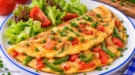 Goldgelbes Paprika-Omelett mit grünen Paprikastreifen, Tomaten und frischem Schnittlauch.
