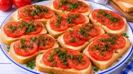 Tomatensandwiches mit frischen Tomatenscheiben, Butter, Petersilie und Pfeffer.