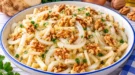 Zwiebelsalat mit feinen Selleriestiften, Zwiebelstreifen und gehackten Walnüssen.