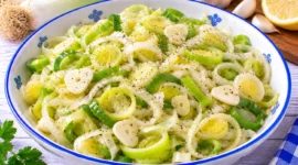 Frischer Porreesalat mit feinen Porreeringen, Knoblauchscheiben und Zitronendressing.