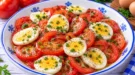 Tomatensalat mit hartgekochten Eierscheiben, Schnittlauch und Zitronendressing.