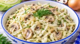 Cremiger Weißkohlsalat mit Champignons, Zwiebeln, Joghurt und frischem Dill.